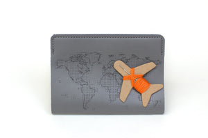 Grey passport cover with plane needle and thread