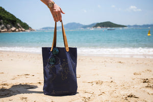 Navy stitch tote bag at beach. Travel bag perfect for recording your travels with cross-stitches 